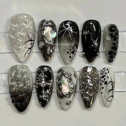 Collection of black, silver, and white nail art designs on a white background