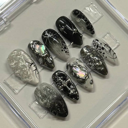 Set of black and silver nail art designs on clear plastic sheets.